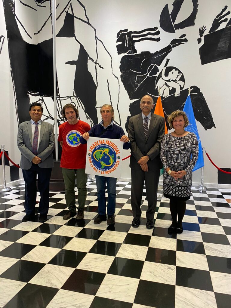 Delegación de Mundo sin Guerras se reúne con representantes de India en la ONU 15.10.24 - Nueva York, Estados Unidos - Juan Gómez Valdebenito Este artículo también está disponible en: Inglés El día de hoy, lunes 14 de octubre de 2024, una delegación de Mundo sin Guerras y sin Violencia y equipo base de la Tercera Marcha Mundial por la Paz y la No Violencia, compuesta por Alessandro Capuzzo de Italia, Juan Gomez de Chile y Vanessa Vaglio de Costa Rica, se reunieron con el embajador y representante permanente de India en Naciones Unidas, Sr. Parvathaneni Harish y con el sr. Ramu Damodaran, Observador Permanente en Naciones Unidas de la Universidad para La Paz, en las oficinas de la Embajada de India en Nueva York. La organización Mundo sin Guerras y sin Violencia en el espíritu de la Tercera Marcha Mundial por la Paz y la No Violencia, agradeció de manera efusiva el que uno de los países más grandes del planeta, diera su apoyo a la marcha y se sumara a nuestro esfuerzo por la paz y no violencia en el planeta. El Sr Embajador fue enfático en la necesidad de que las personas, los grupos y los países se puedan sentar a negociar de formas cordiales, diplomáticas, los conflictos que existen en los diversos grupos y países en el planeta. Nos comentó que el primer ministro indio Sr Narendra Modi ha sido mediador entre Ucrania y Rusia, lo mismo que entre Israel y Palestina tratando de llegar a acuerdos diplomáticos y de salida a la crisis de manera no violenta. La organización le presentó un documento que desea promover la neutralidad de la región de Trieste, ya que la zona de Trieste es la llegada final de la Ruta del Algodón, de suma importancia para India y esta relacionada con la Paz de la zona de medio oriente. Esta neutralidad esta basada en la resolución número 16 del Consejo de Seguridad de la ONU. El Embajador quedó de revisar el documento con su departamento legal. Nuestra organización apela a la buena voluntad de los puebles en que las diferencias se conversen y se negocien por los caminos diplomáticos, siendo indispensable la terminación de todas las guerras o formas de violencia en el planeta, como único camino para salvar a la humanidad de la autodestrucción. El Embajador está igualmente de acuerdo con nuestra postura e indicó que la cultura de Paz y no Violencia de India, basado en los principios de Gandhi, deben ser los pilares de la humanidad. Igualmente se coincidió que el camino para que la humanidad salga de estos días grises y turbios es que se abran los canales de diálogo y conversación. Así mismo el Embajador comenta su preocupación por los conflictos armados en el resto del planeta como en África, el de Sudan que cobra más vidas que el conflicto en Ucrania, igualmente preocupante y que no decir de la crisis actual en Medio Oriente . Coincidimos en que el camino debe ser presionar y ser constante en las posiciones pro dialogo y no violencia, y perseverar en ser mediadores y facilitadores de la Paz. El Embajador apoya la 3a Marcha Mundial por la Paz y la No Violencia y pide que sigamos en nuestro camino adelante. Artículo extraido de Pressenza